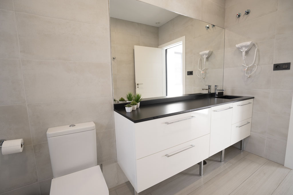 a bathroom with a mirror and white cabinets