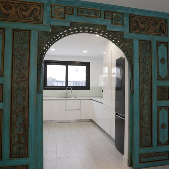 a room with a blue door and white cabinets