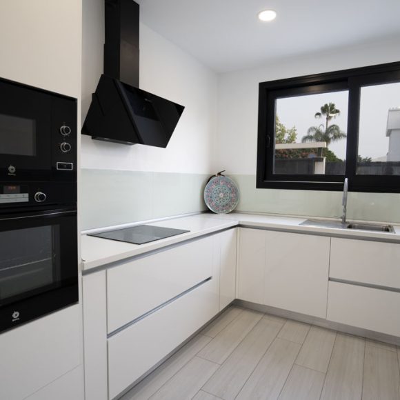 a kitchen with white cabinets and black appliances