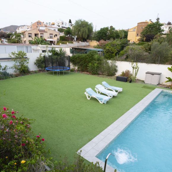 a pool and chairs in a backyard